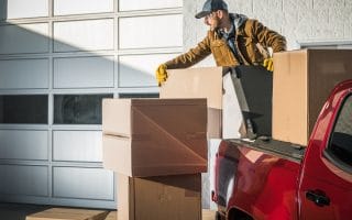 Man unloading a red pick up truck, indicative of making money with his pick up