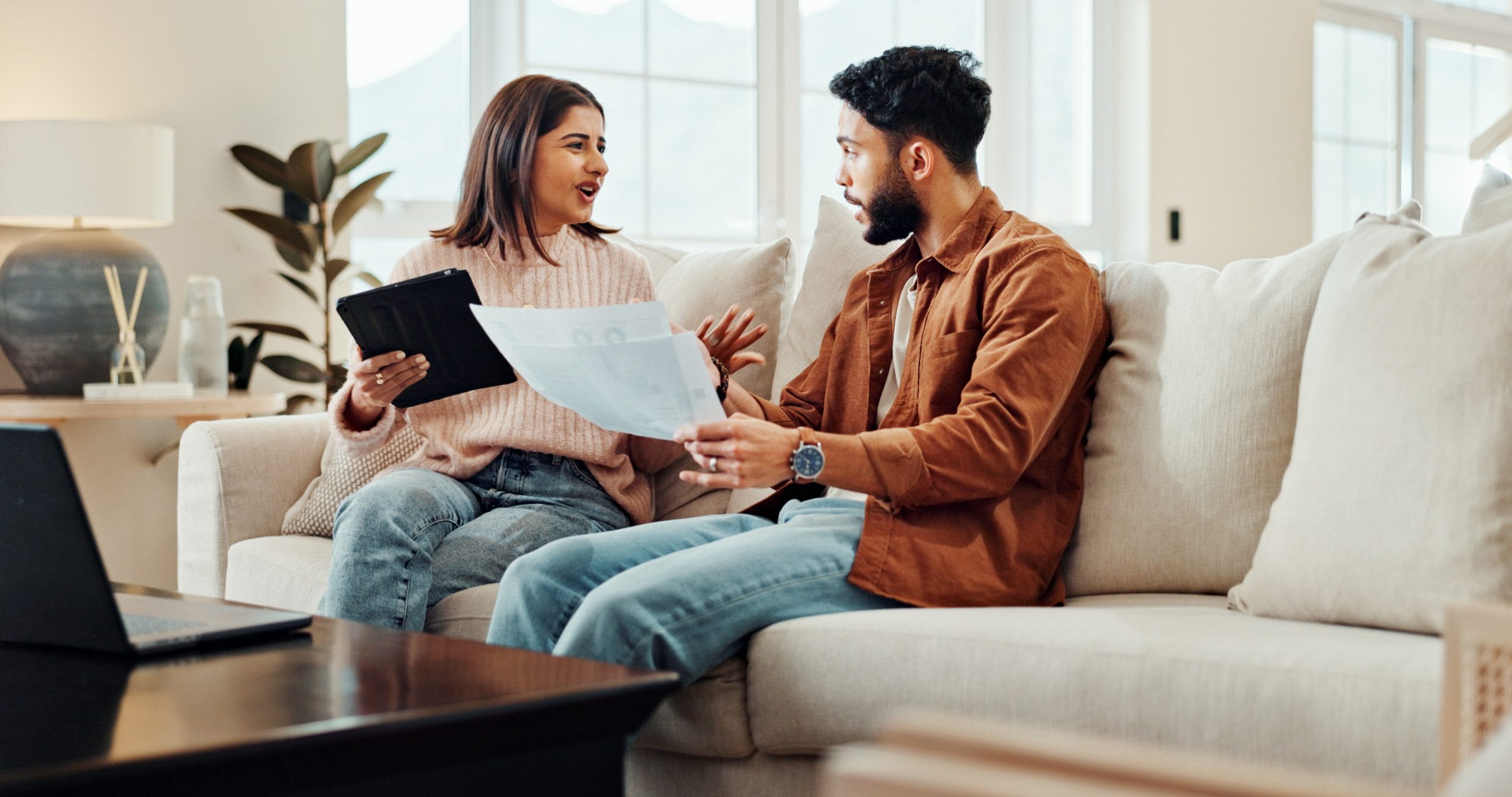Finance, couple and document in home for fight, budget argument or savings loss on tablet. Man, woman and paper in living room for loan, stress or conflict for debt crisis or bankruptcy with expenses.