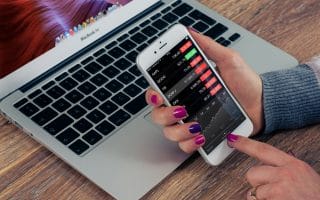 holding phone with investing apps