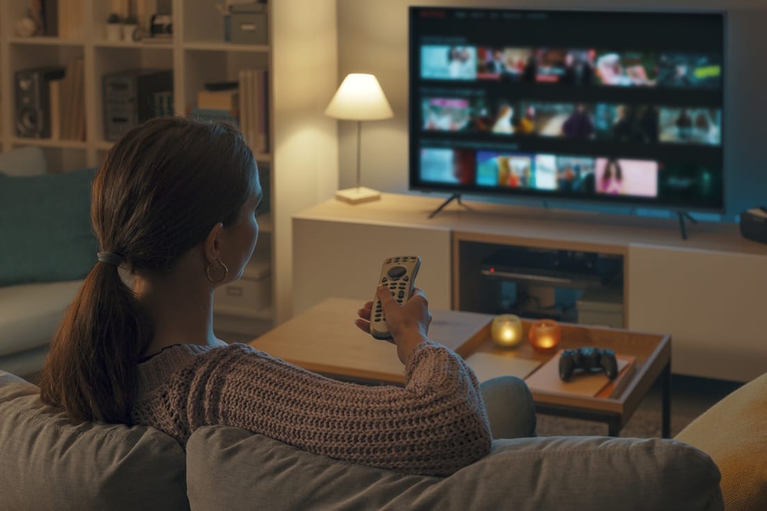 Big screen TVs are a large energy drain; woman watching tv