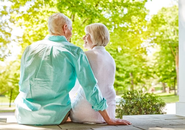 Baby boomer couple sitting on a porch, indicating boomers are happy to stay put.